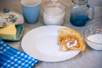 Pancakes on a white plate with powdered sugar, served for Breakfast