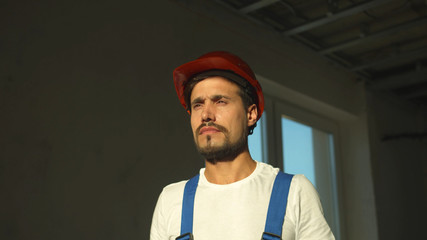 Builder stands and puts on protective helmet