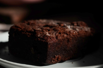 Homemade chocolate cake in white dish and sunlight and space for write wording, unhealthy sweet...