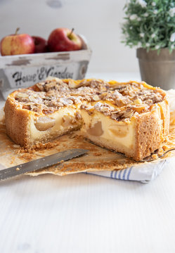 Bratapfelkuchen mit &Auml;pfeln und Mandelbl&auml;ttchen auf hellem wei&szlig;en Holzgrund