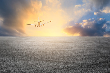 Empty asphalt road and sky airplane landscape at sunset