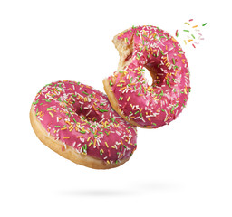 flying bitten red glazed round donuts with sprinkles isolated