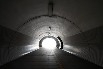 Exit from the empty round concrete tunnel outside, with light in the end. Inside empty round tunnel.