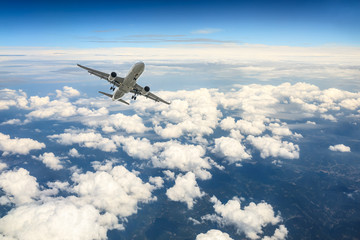 Obraz premium Airplane flying at high altitude over green mountains and sky at sunrise
