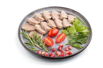 Boiled pork tongue with tomatoes and herbs isolated on white background. Side view.