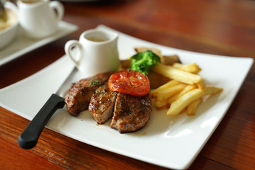 Juicy grounded pork steak with tomato serving with potato chips and black pepper sauce