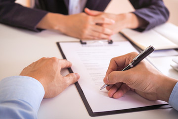 The business team read the documents before signing the contract, signed the agreement to invest Start a new project in the office.
