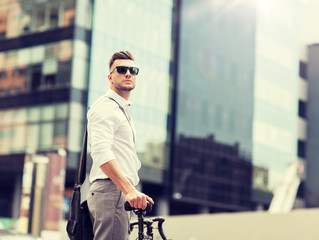 business, lifestyle, transport and people concept - young man with bicycle on city street