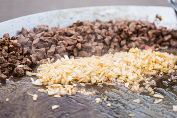 Delicious slices meat on open grill, outdoor kitchen. Food festival in city. Tasty food roasting, food-court. Summer picnic