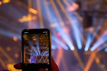 Naklejka premium Scene, stage lights with colored spotlights and smoke, laser lights background displayed in the screen of a smartphone 
