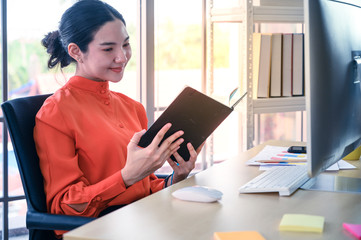 Business women holding book at office workplace.