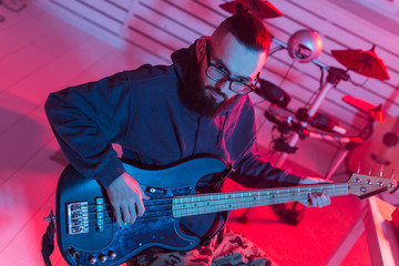 Obraz premium Create music and a recording studio concept - Bearded funny man guitarist recording electric guitar track in home studio