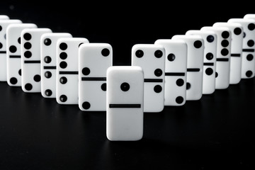 Domino pieces put in a row on black background