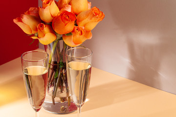 photo of champagne glasses with roses in a vase close up