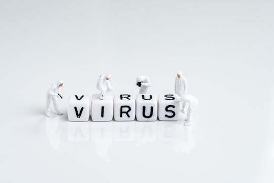 Miniature people inspector team with protective suit inspecting cube block combine the word Virus using as quarantine or spreading of corona virus, COVIS flu outbreak or computer virus concept - Powered by Adobe