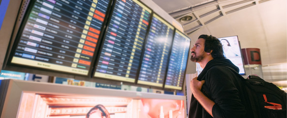 A man near the schedule board at the airport