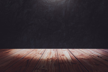 Empty wooden deck table top over dark grunge wall with spot light Ready for used us display or montage products design.