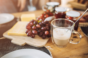 Cheese, grapes and jam - a delicious hearty breakfast with coffee on the table