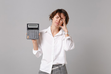 Tired young business woman in white shirt posing isolated on grey wall background. Achievement...
