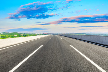 Fototapeta premium Empty asphalt highway and city suburb skyline in Shanghai at sunset.
