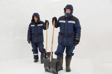 Two workers in blue jackets for snow removal