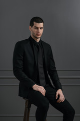 Young handsome businessman in black shirt and black suit