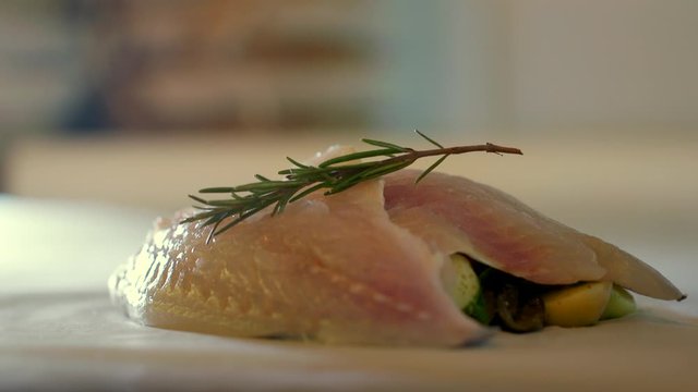 Closeup of preparing a fresh gilt-head bream fish meat with rosemary