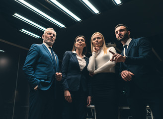 The four business people standing indoor