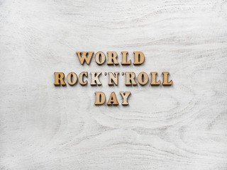 Wooden letters of the alphabet in the form of the words ROCK 'N' ROLL DAY lying on the table. Beautiful card. Isolated background, wooden surface. Congratulations for relatives, friends and colleagues