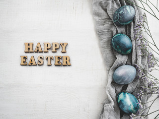 Wooden letters of the alphabet in the form of the words HAPPY EASTER on a white, isolated background. Top view, close-up. Congratulations for loved ones, relatives, friends and colleagues