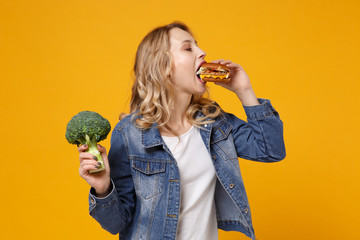 Young woman in denim clothes posing isolated on yellow orange wall background studio portrait....