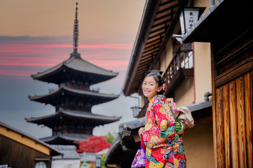 woman holding retro umbrella in old fashion style traditional kimono, walks  in the middle  park of garden village in autumn, travel and visit japan on incoming sport event