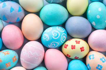 Fototapeta na wymiar Colorful Easter eggs dyed by colored water with beautiful pattern on a pale blue background, design concept of holiday activity, top view, full frame.