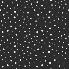 Seamless pattern with white dots of different diameters on a black background. Vector illustration.
