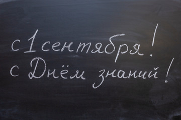 the inscription in Russian "since September 1! Happy knowledge day !" Chalk Board, handwritten text.