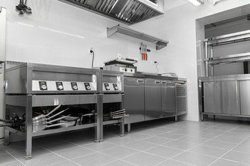 Design of the working area of the commercial cafe kitchen with stainless steel equipments, hot shop, food industry.