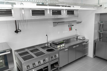 Design of the working area of the commercial cafe kitchen with stainless steel equipments, hot...