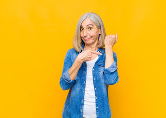 senior or middle age pretty woman looking impatient and angry, pointing at watch, asking for...
