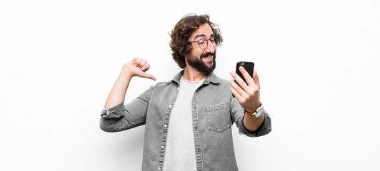 young crazy cool man using his smartphone against white wall