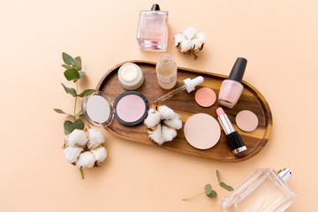 beauty, natural cosmetics and make up products concept - makeup, perfume with cotton flower on...