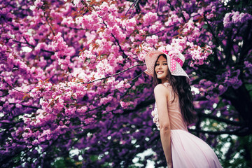 girl stands near a blossoming tree