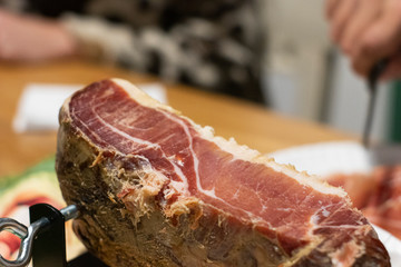 Jamon Curado sobre mesa familiar con fondo desenfocado, fresco y en primer plano