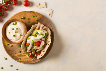 Mini tortillas with tomato salsa, avocado and boiled chicken. Top view.