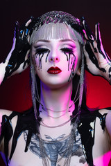 Colorful portrait of a young gothic woman crying with black blood