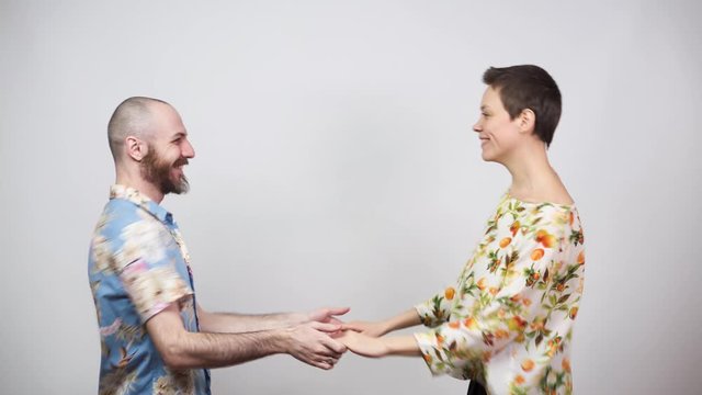Happy couple having fun. Swing dancers wearing hawaiian shirts on white background. Man and woman are dancing boogie woogie dance. Social dance concept.
