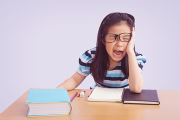 Bored and tired asian student girl doing homework, isolated on grey background