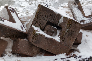 Bank protection - concrete breakwaters on the shore of Lake Ladoga on a cloudy winter day