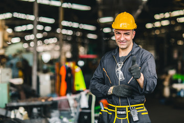 Portrait of foreman labor worker engineer working in industrial factory and waring safty suit happy smile hand show thumb up.