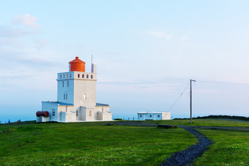 Fototapeta na wymiar Landscape with white lighthouse at Cape Dyrholaey, located on south coast of Atlantic ocean in Iceland