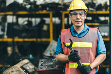 Asian Labor worker engineer with safety suit and helmet working in industry factory handle...